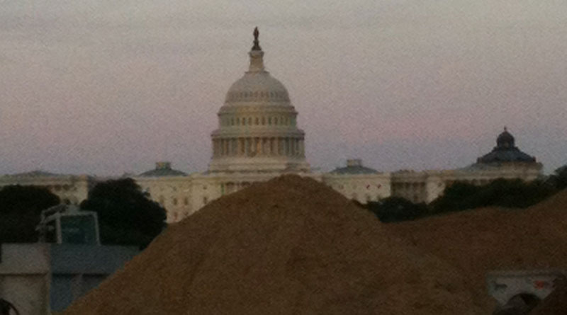 Construction on the National Mall leaves a pile of dirt in front with the U.S. Capitol dome in the background.